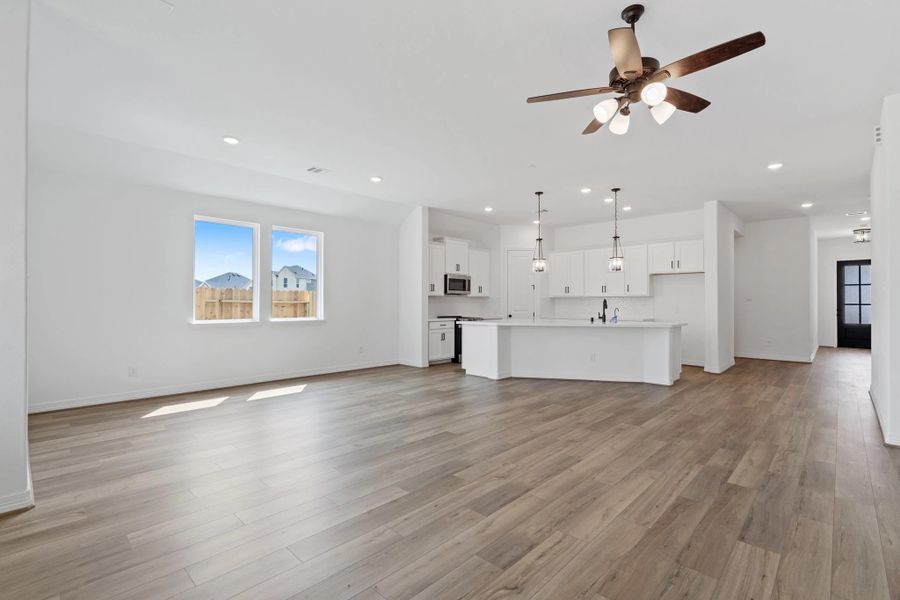 Family room open to kitchen and dining area. Note: Sample product photo. Actual exterior and interior selections may vary by homesite. Photo may be virtually staged