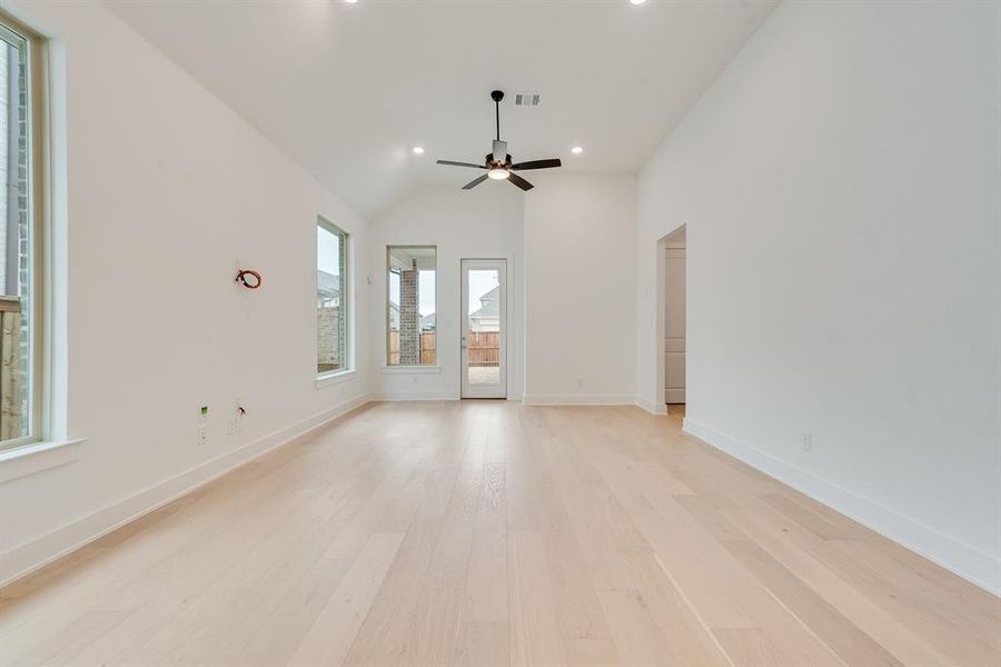 Empty room featuring light wood-style floors, recessed lighting, and high vaulted ceiling Empty room featuring light wood-style floors, recessed lighting, and high vaulted ceiling