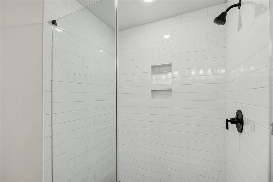 Crisp subway tile surrounds this modern walk-in sh