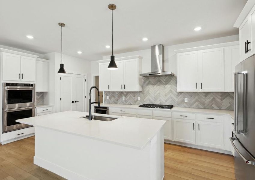 The kitchen has beautiful white wood cabinets with black hardware.