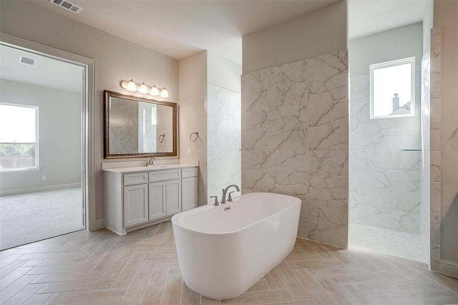 Bathroom featuring parquet floors, separate shower and tub, and vanity