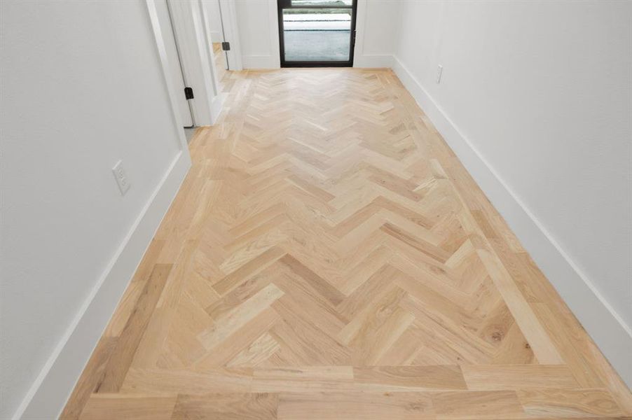 A stunning close-up showcasing the exceptional craftsmanship of the custom herringbone white oak hardwood flooring in the grand entry foyer. Every detail reflects timeless elegance and impeccable quality—simply breathtaking! A stunning close-up showcasing the exceptional craftsmanship of the custom herringbone white oak hardwood flooring in the grand entry foyer. Every detail reflects timeless elegance and impeccable quality—simply breathtaking!
