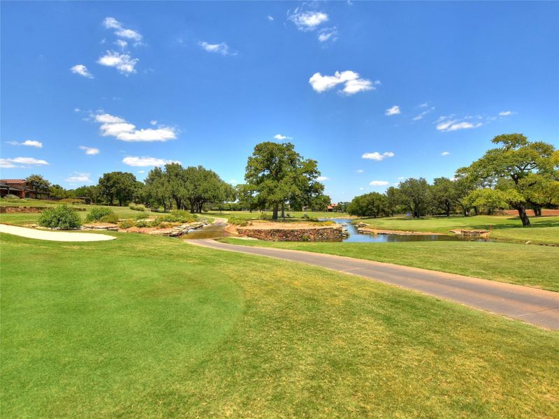 Surrounding community with a water view and a yard