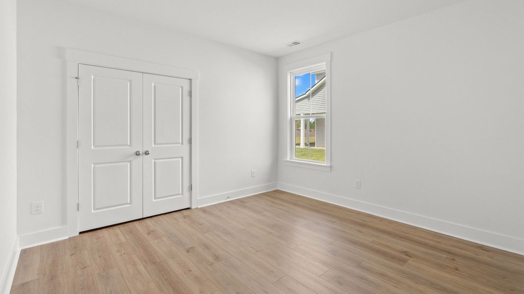 Bright secondary bedroom with closet storage and backyard views. Bright secondary bedroom with closet storage and backyard views.