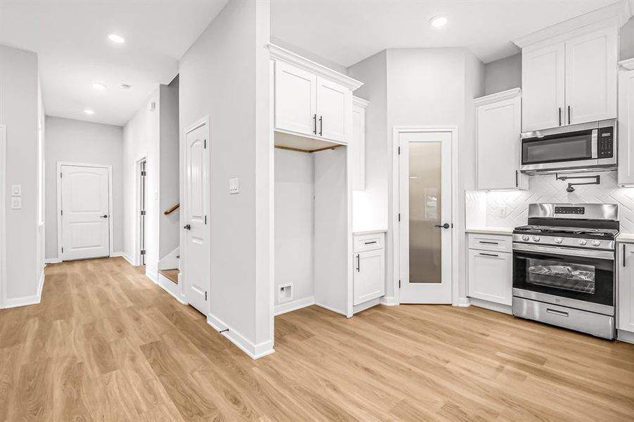 A bright and open space with stairs, closet and office just beyond.