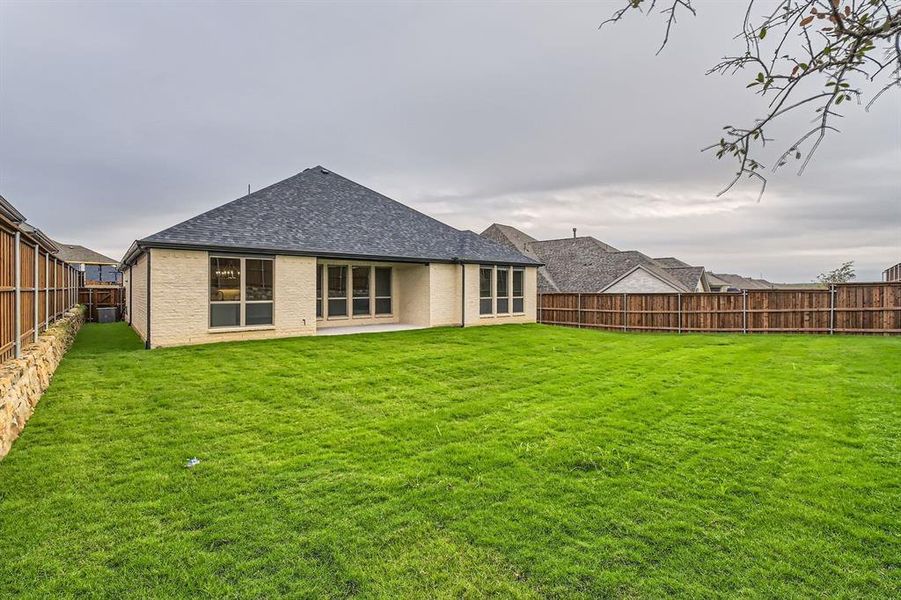 Back of house with a lawn