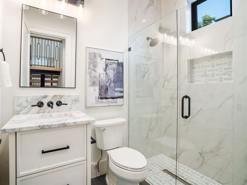 Bathroom with vanity and a marble finish shower
