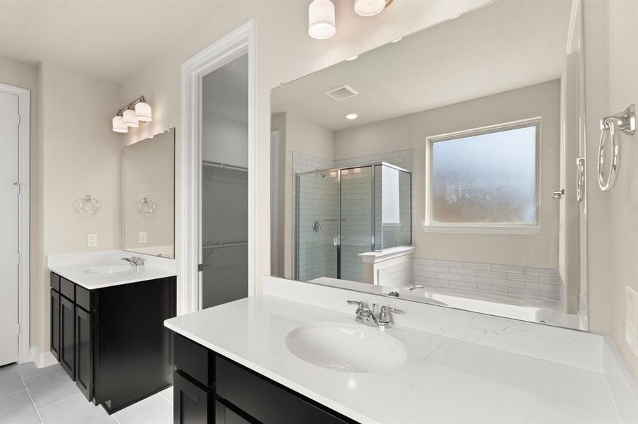 The en-suite bathroom offers a spa-like atmosphere with its elegant design, high end finishes, and tasteful lighting, creating a retreat within your own home.