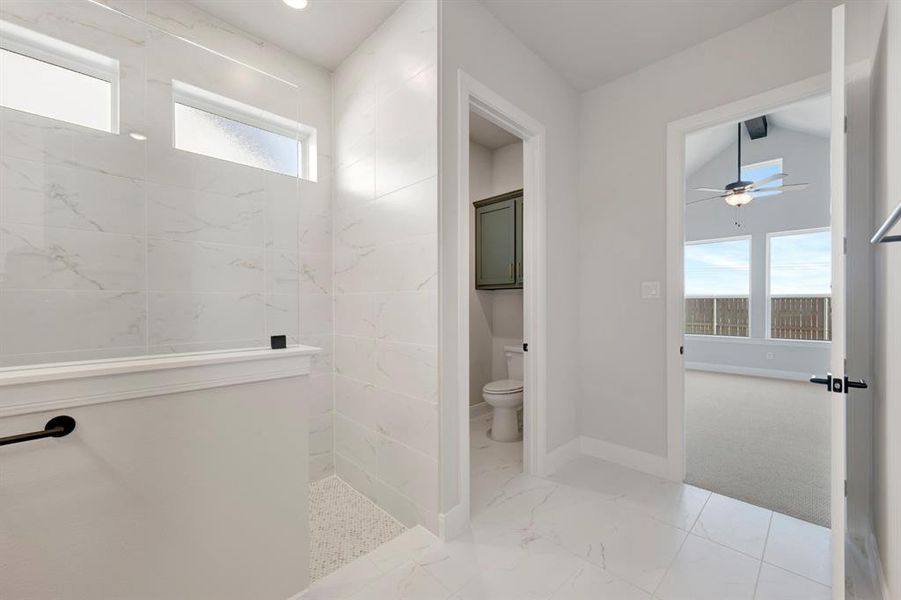 Full bathroom with a walk in shower, light marble finish floors, and a ceiling fan Full bathroom with a walk in shower, light marble finish floors, and a ceiling fan
