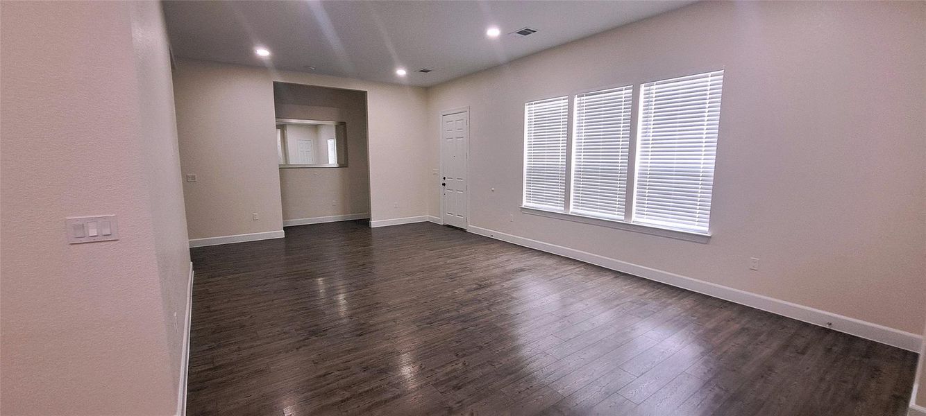 Empty room featuring dark wood-style floors and recessed lighting