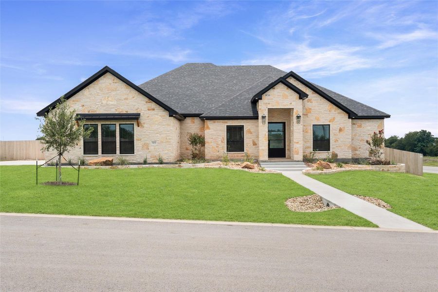 An inviting stone facade with a neatly landscaped yard creates a charming curb appeal. An inviting stone facade with a neatly landscaped yard creates a charming curb appeal.