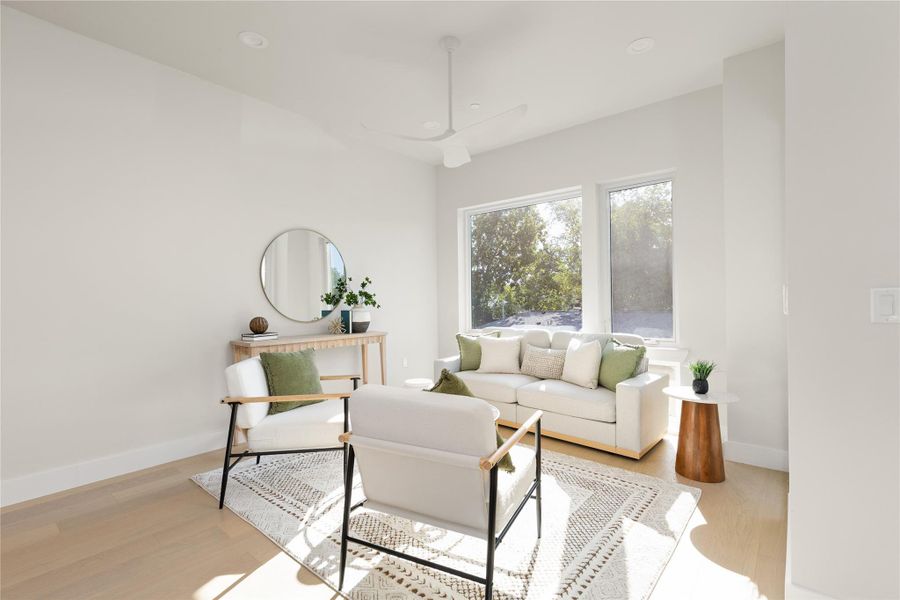 Large windows and pristine wood floors define this bright living space.