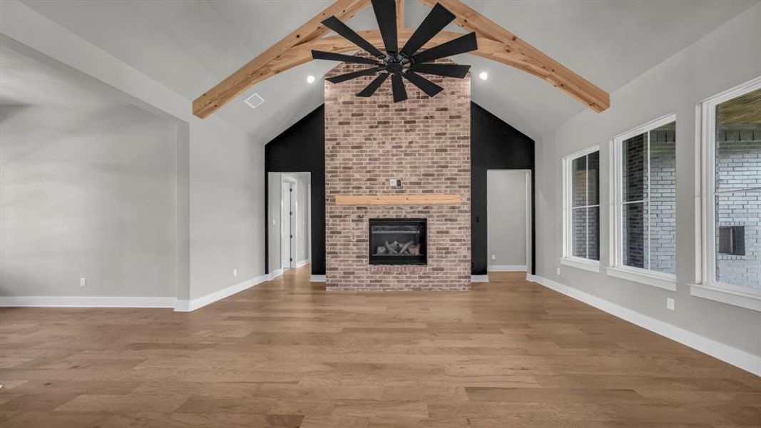 Vaulted ceiling with exposed wood beams and a large ceiling fan
