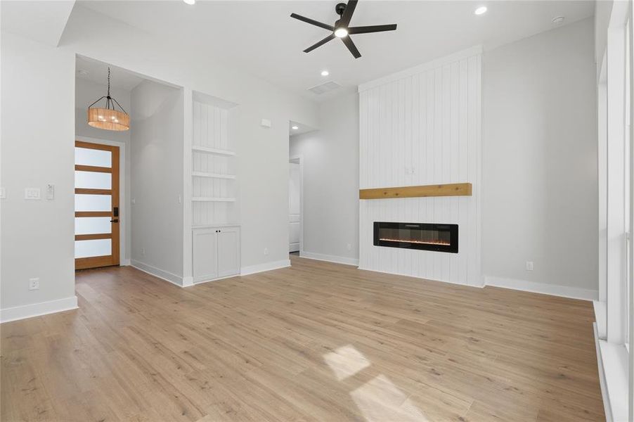Living space with wood-finish flooring and a contemporary linear fireplace Living space with wood-finish flooring and a contemporary linear fireplace