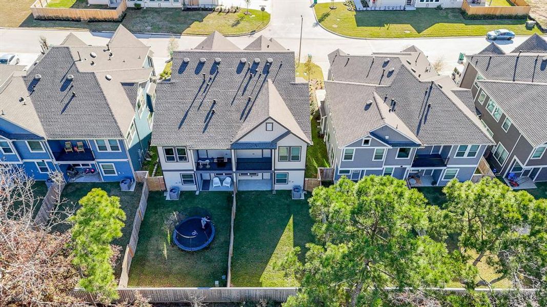 An aerial view highlights the expansive private fenced yard, complete with two covered patios, offering plenty of space for outdoor enjoyment.