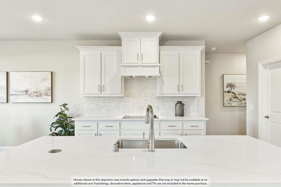 White kitchen with shaker cabinets, marble backsplash, and large island with undermount sink