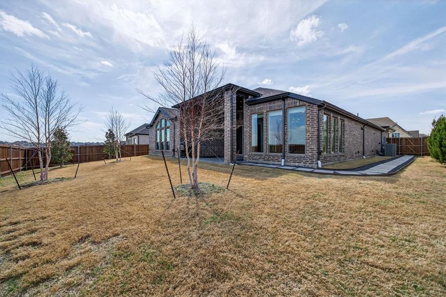 Back of property featuring brick siding, a fenced backyard, and a patio Back of property featuring brick siding, a fenced backyard, and a patio