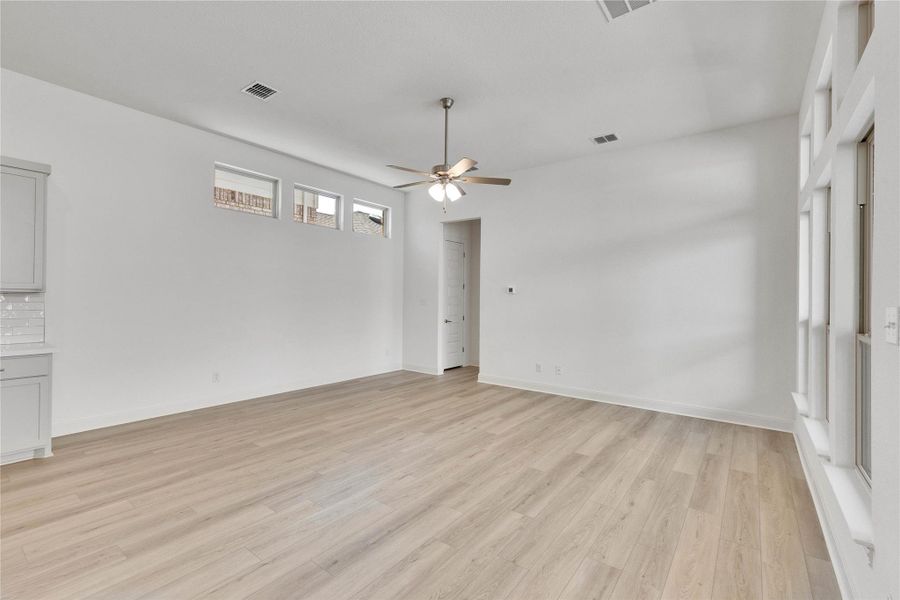 Unfurnished room featuring a ceiling fan and light wood-style floors Unfurnished room featuring a ceiling fan and light wood-style floors