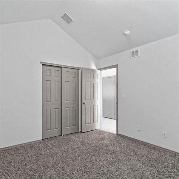 Another view of the second of three secondary bedroom featuring a sliding door closet, vaulted ceiling and lush carpeting. **This image is from another Saratoga Home with similar floor plan - Myrtle Floorplan.**