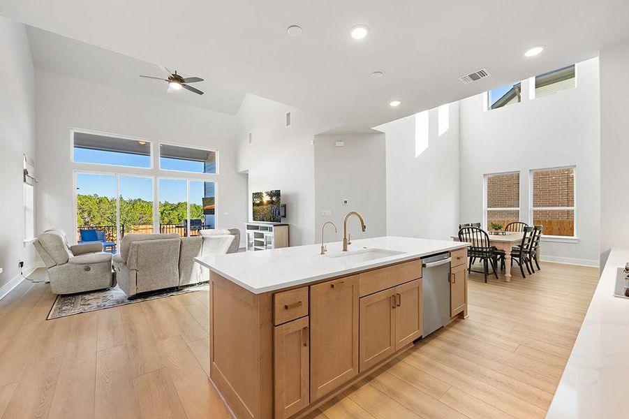 An open floorplan seamlessly connects the central kitchen island to the bright dining area.