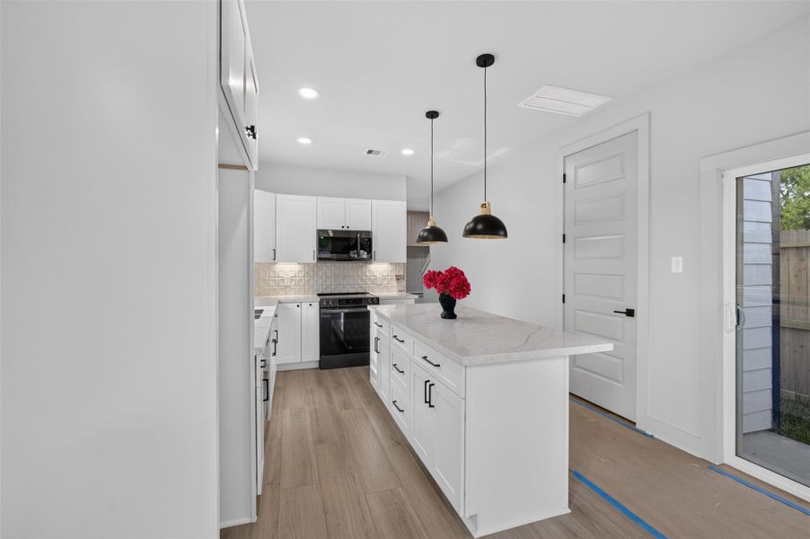 This modern kitchen features sleek white cabinetry, a spacious marble island, and chic pendant lighting. Natural light pours in through large windows, creating a bright and inviting space perfect for cooking and entertaining. This modern kitchen features sleek white cabinetry, a spacious marble island, and chic pendant lighting. Natural light pours in through large windows, creating a bright and inviting space perfect for cooking and entertaining.