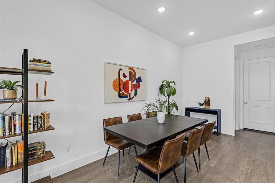 Dining space with wood finished floors and recessed lighting