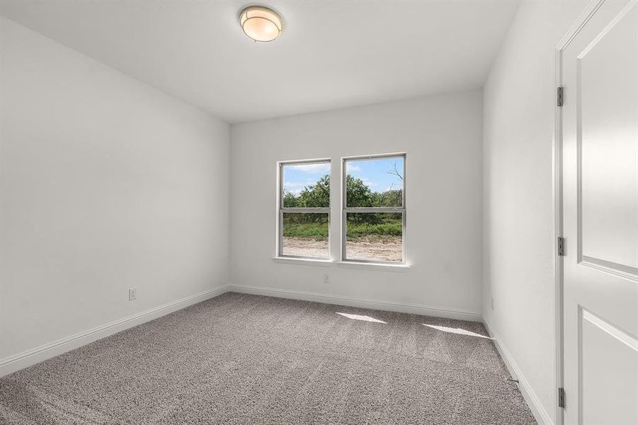 Unfurnished room featuring light colored carpet and baseboards
