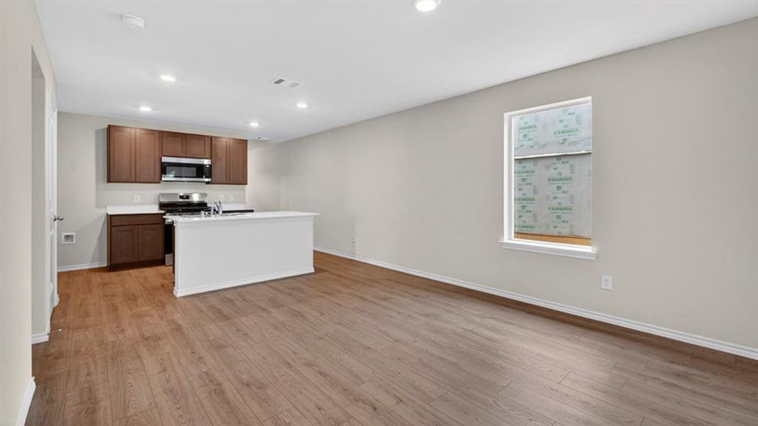 Open-concept living space with wood-finish flooring