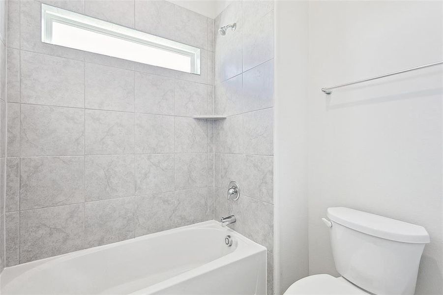 Bathroom featuring toilet and tiled shower / bath