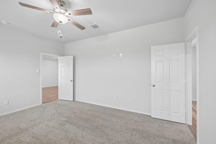 Spacious room featuring neutral carpeting and a ceiling fan with integrated lighting
