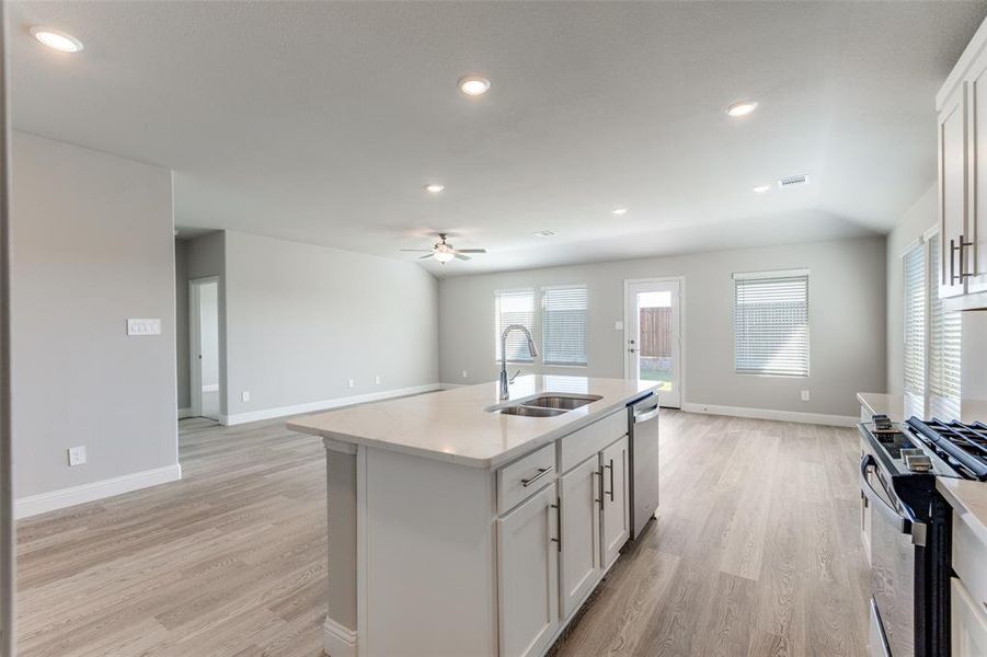 Kitchen featuring white cabinetry, open floor plan, gas stove, recessed lighting, and light wood-style floors
