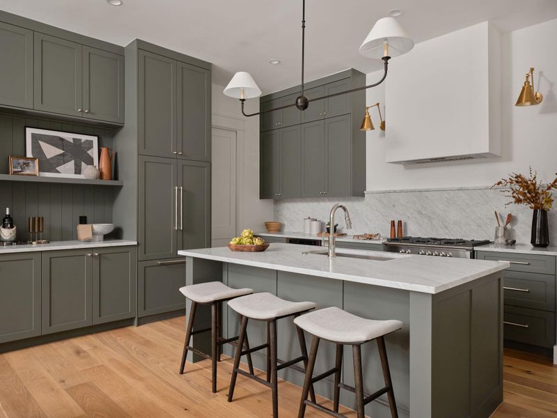 Kitchen with gray cabinetry, pendant lighting, a kitchen bar, and light wood-style floors Kitchen with gray cabinetry, pendant lighting, a kitchen bar, and light wood-style floors