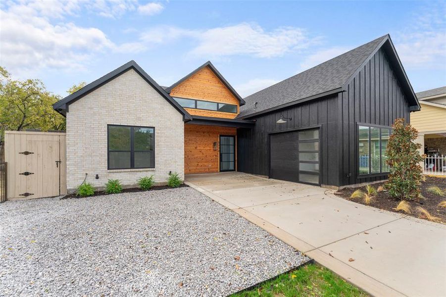 Modern farmhouse with concrete driveway, an attached garage, board and batten siding, and a shingled roof