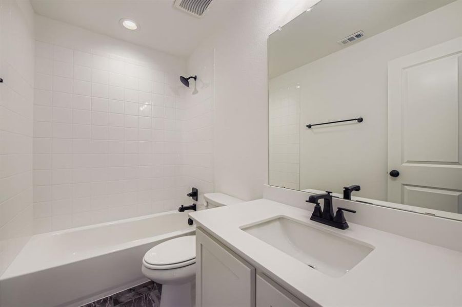 Bathroom featuring vanity, shower combination, and recessed lighting Bathroom featuring vanity, shower combination, and recessed lighting