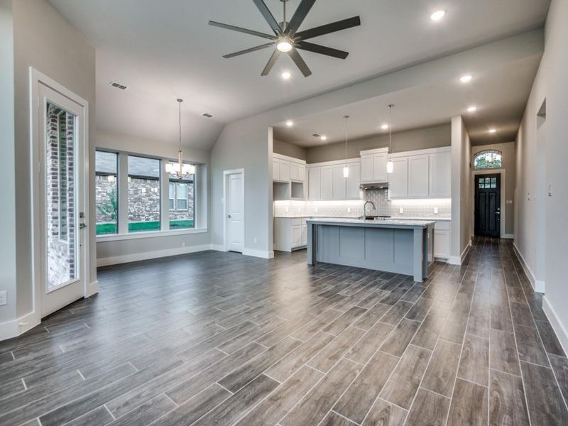 Kitchen with open floor plan, white cabinetry, and decorative backsplash Kitchen with open floor plan, white cabinetry, and decorative backsplash