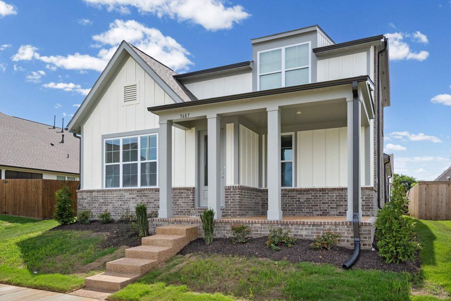 Contemporary residence featuring a brick and vertical siding exterior, covered porch, multiple windows, and a landscaped front yard with concrete steps Contemporary residence featuring a brick and vertical siding exterior, covered porch, multiple windows, and a landscaped front yard with concrete steps
