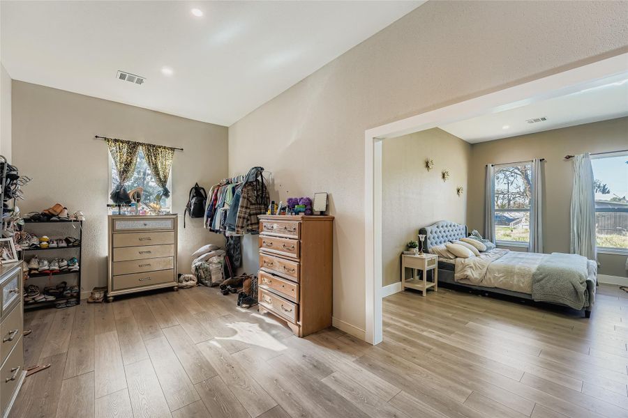 Bedroom featuring light wood-style flooring and multiple windows Bedroom featuring light wood-style flooring and multiple windows