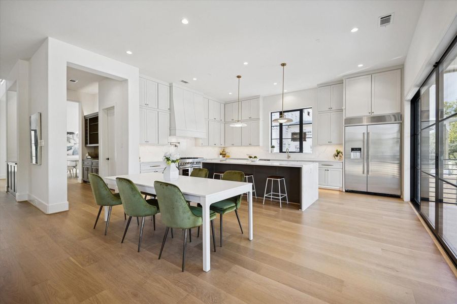 The casual dining off of the kitchen has access to the butler pantry and bar. Door to the hidden pantry/prep area can be seen in the bar area.