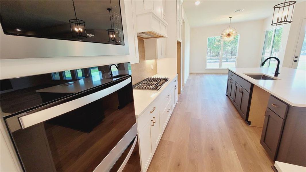 Modern kitchen featuring a gas range, built-in oven, and a central island with an undermount sink