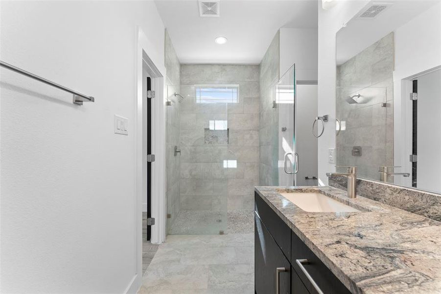 Bathroom with a tile shower and vanity