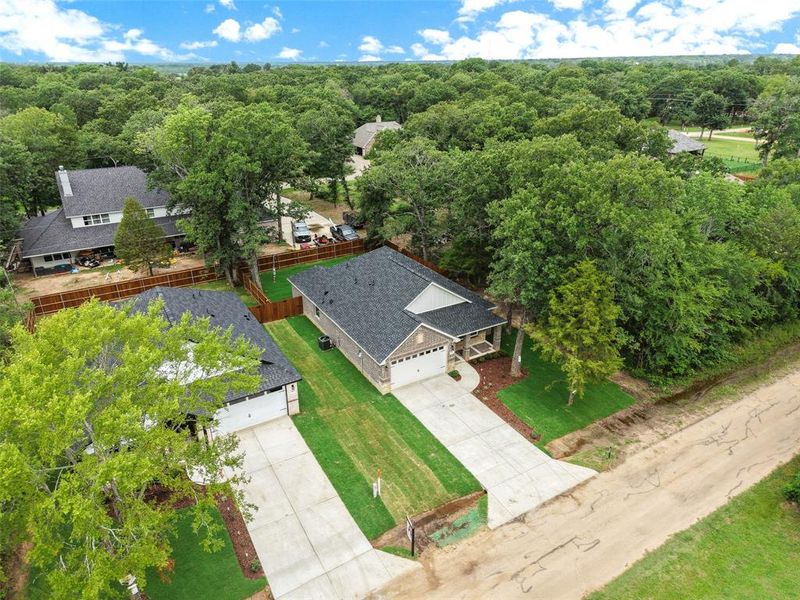 New construction residence featuring a dark shingle roof, light-colored siding, and a prominent attached garage New construction residence featuring a dark shingle roof, light-colored siding, and a prominent attached garage