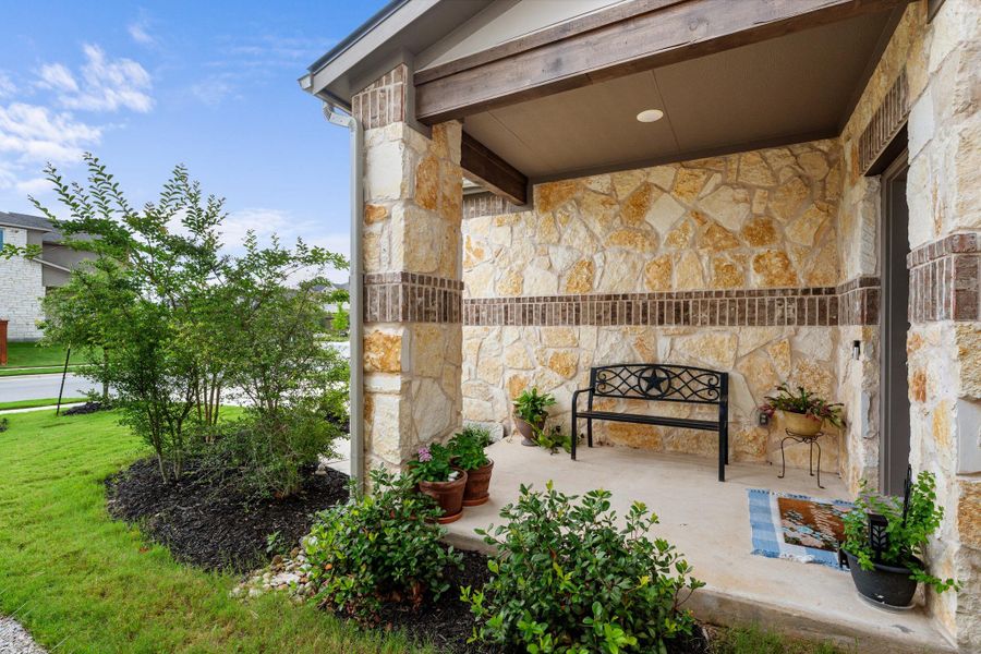 A welcoming front porch features natural stone and a cozy seating area. A welcoming front porch features natural stone and a cozy seating area.