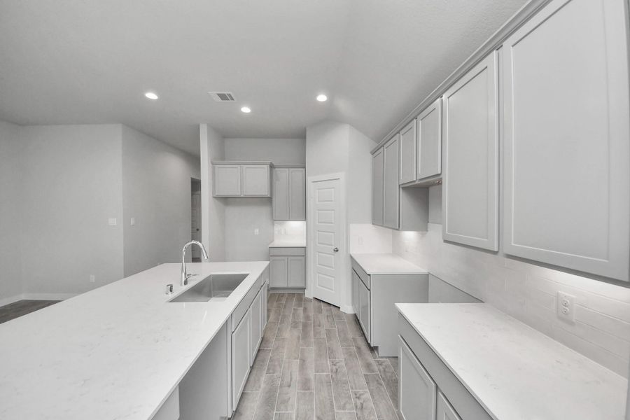 Discover another perspective of this stunning kitchen, generously appointed with an abundance of counter space. Sample photo of completed home with similar floor plan. Actual colors and selections may vary. Discover another perspective of this stunning kitchen, generously appointed with an abundance of counter space. Sample photo of completed home with similar floor plan. Actual colors and selections may vary.