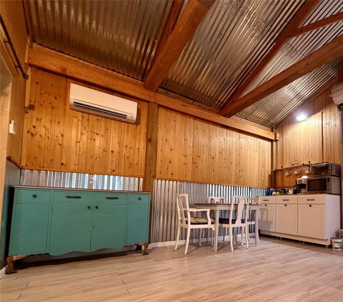 Rustic-inspired kitchen and dining area with exposed wood beams and corrugated metal accents. Coffee Bar.