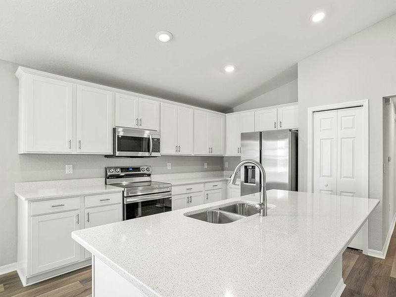 Your bright, open kitchen features an island, quartz counters, and Samsung SS appliances.