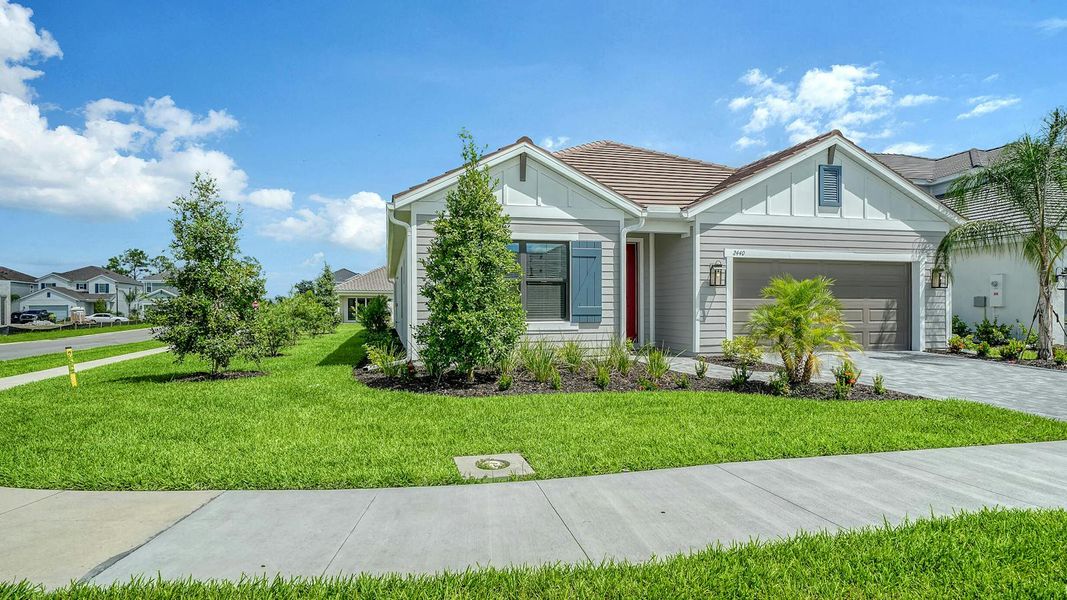 Front exterior of a new home in Windward Real Estate and Homes for Sale in Sarasota, FL - Neal Communities, Lakewood Ranch, FL, highlighting curb appeal (Image 2).