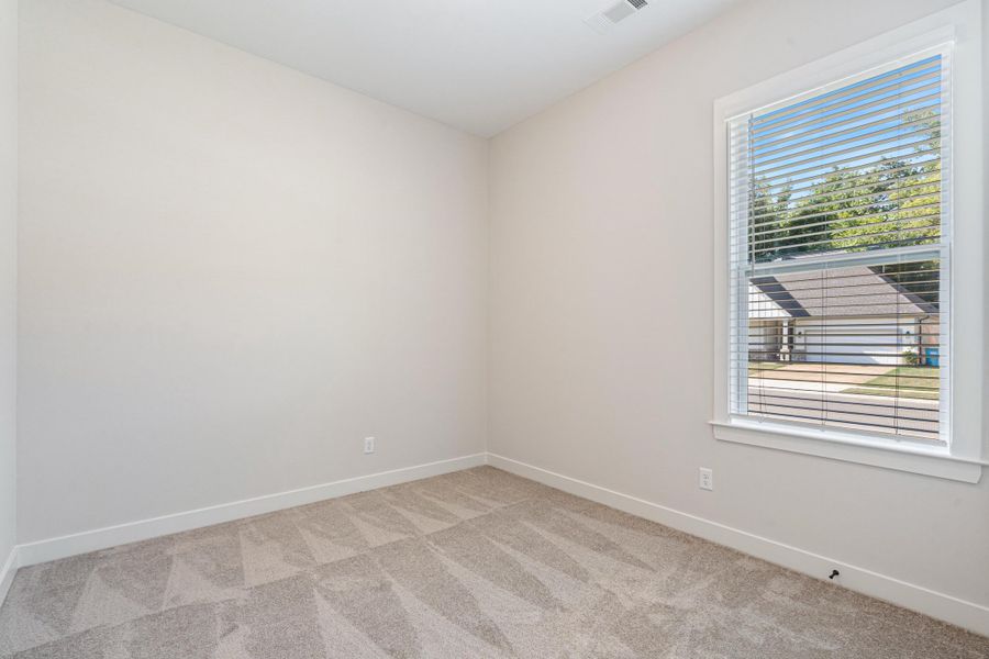 Neutral-toned walls complement the geometric patterned carpet Neutral-toned walls complement the geometric patterned carpet