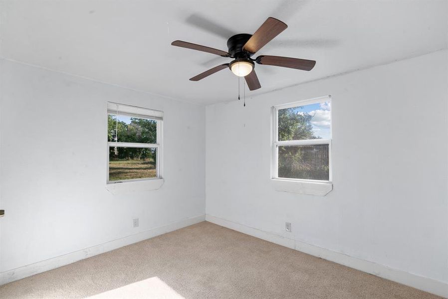 Unfurnished room featuring ceiling fan and light colored carpet