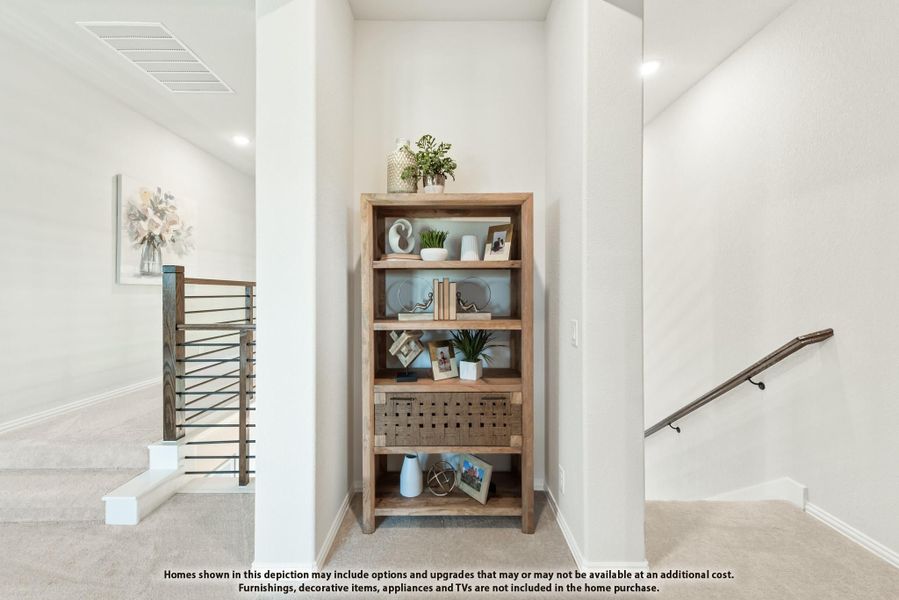 Upstairs hallway with wood bookshelf, decorative items, and staircase railing with metal balusters Upstairs hallway with wood bookshelf, decorative items, and staircase railing with metal balusters
