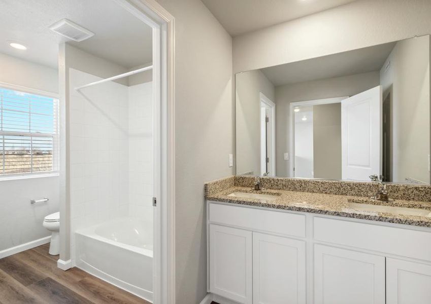 The secondary bathroom has a dual sink vanity and tub/shower combo.